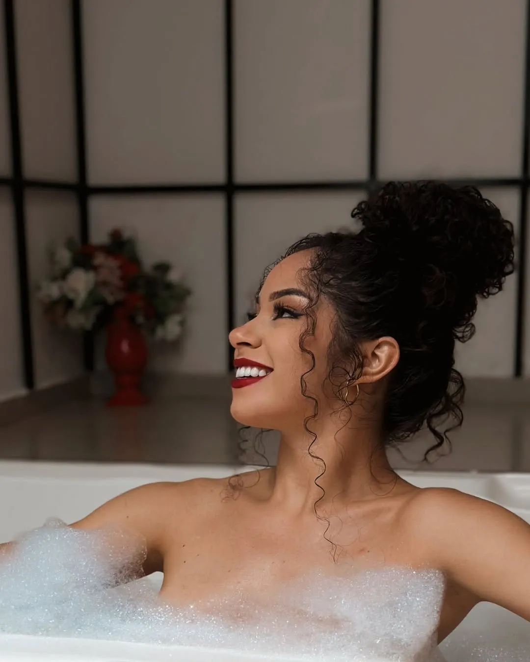 Hóspede relaxando em uma banheira repleta de espuma