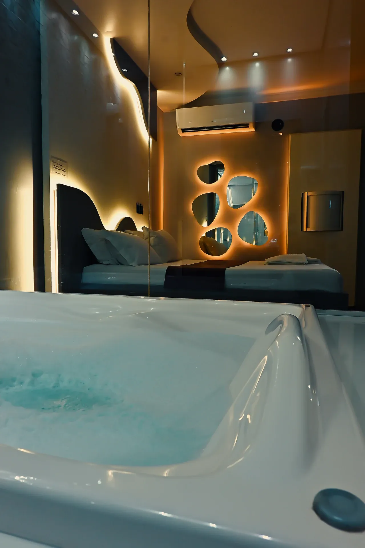 Hidromassagem e cama da Suíte Luxo Hidro sob iluminação âmbar
