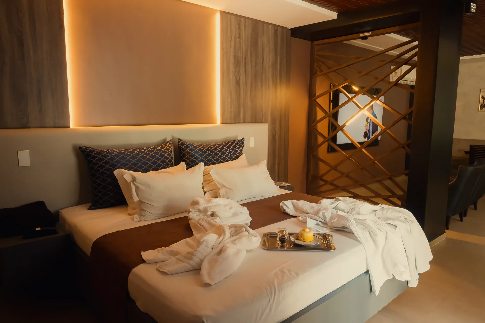 Cama da Suíte Opium com toalhas decorativas, roupões e bandeja de sobremesa